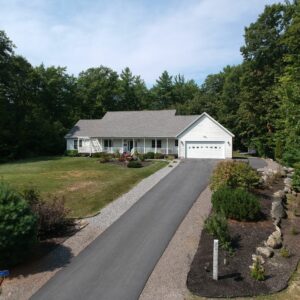 Exterior of a modern farmhouse on a hill surrounded with trees