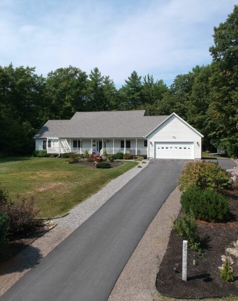 Exterior of a modern farmhouse on a hill surrounded with trees