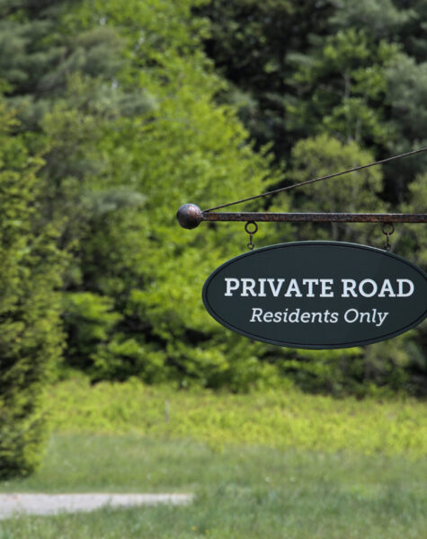 private road (residents only) sign on wooden signpost with road and trees in background (sky, clouds, grass, lawn) post, rural road, unpaved path